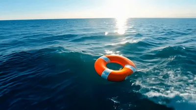 Lifebuoy Floating On Calm Ocean Waves At Sunset