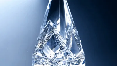 Crystal Sculpture Rotating Against A Soft Blue Background