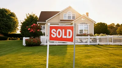 Sold Real Estate Sign In Front Of Suburban House