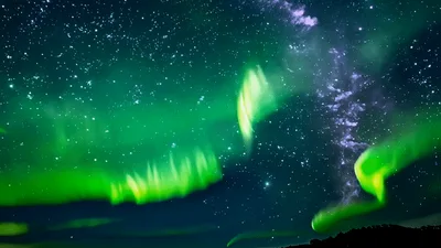 Vibrant Aurora Borealis Dancing Over A Dark Landscape