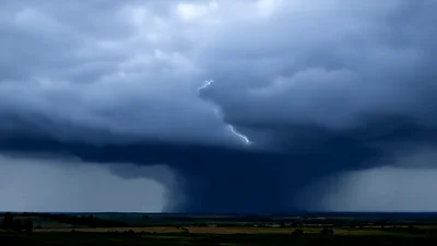Supercell Thunderstorm With Lightning Strikes Over Rural Landscape