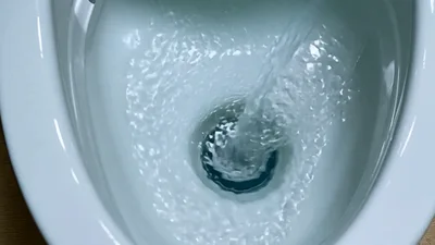 Water Pouring Into A White Ceramic Toilet Bowl