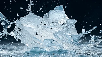 Ice Block Shattering Into Fragments On Dark Surface