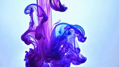 Purple And Blue Ink Droplets Dissolving In Clear Water