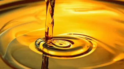 Golden Oil Pouring Into A Large Container