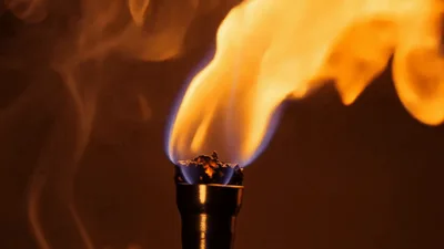Burning Torch Flame Against Dark Background