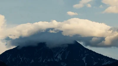 Lenticular Clouds Forming Over A Mountain Peak