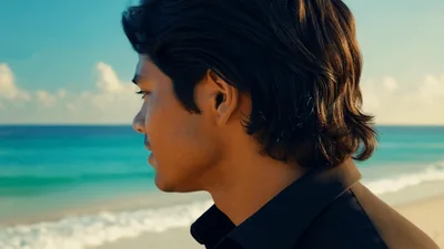 Young Man Turning Head To Look At Tropical Beach