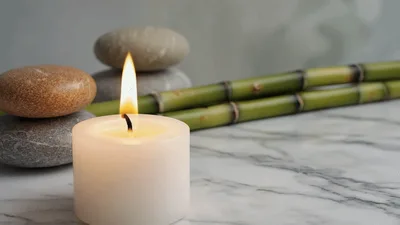Burning White Candle With Zen Stones And Bamboo