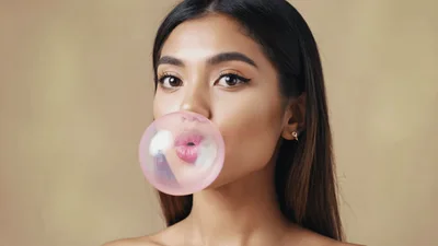 Young Woman Blowing A Pink Bubblegum Bubble