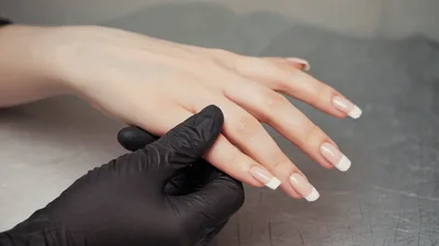 Manicurist Applying Moisturizing Cream To Client Hand
