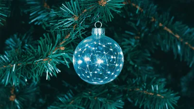 Glowing Geometric Christmas Ornament Hanging On Pine Tree
