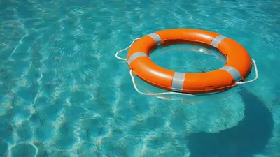 Orange Life Buoy Floating In A Swimming Pool