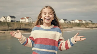 Happy Young Girl Laughing Outdoors Near The Ocean
