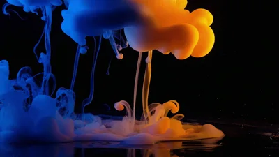 Blue and Orange Ink Clouds Swirling in Water