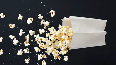Popcorn Spilling Out Of A White Paper Bag