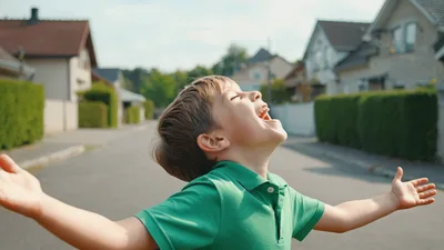 Happy Young Boy Laughing Outdoors In Residential Neighborhood