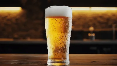 Cold Glass Of Beer With Condensation On Wooden Table