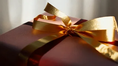 Pink Gift Box With Gold Ribbon On Wooden Table
