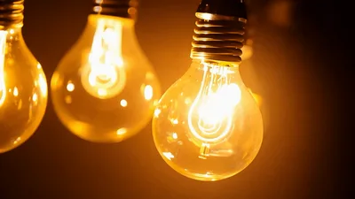 Glowing Vintage Edison Light Bulbs Hanging In Dark Room