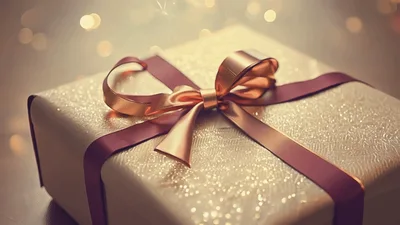 Golden Gift Box With Ribbon Under Sparkling Lights