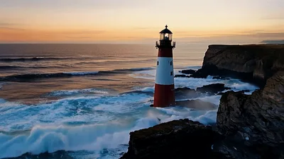 Lighthouse Standing On Rocky Cliff During Sunset