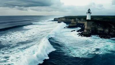 Aerial View Of Lighthouse On Rugged Coastal Cliff