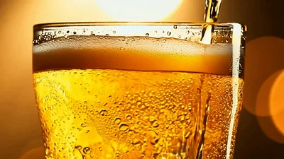 Golden Beer Pouring Into A Chilled Glass