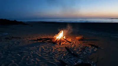 Bonfire Burning On A Sandy Beach At Twilight
