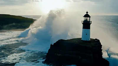Massive Ocean Wave Crashing Against Coastal Lighthouse