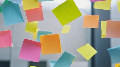 Colorful Sticky Notes Floating Downwards In Office