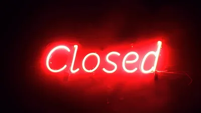 Red Neon Closed Sign Glowing In Dark Background