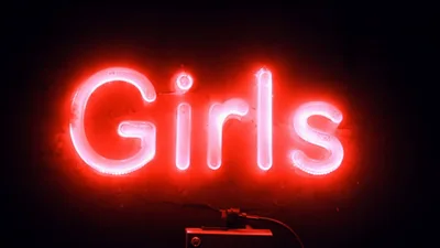 Red Neon Girls Sign Flickering On In Dark Room