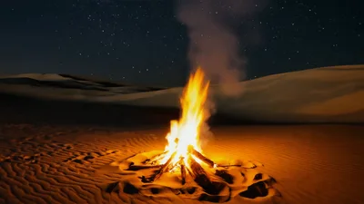 Bright Campfire Burning On Desert Sand Dunes At Night
