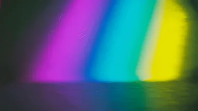 Dynamic Rainbow Light Beams Moving Across Dark Surface