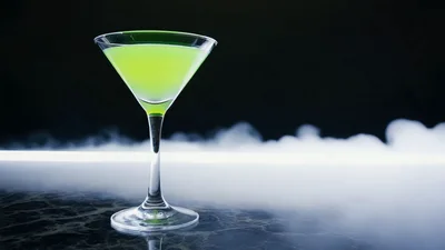 Green Martini Cocktail Glass Surrounded By Rolling Dry Ice Fog