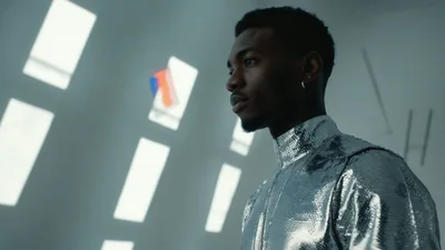 Young Man In Metallic Clothing Standing In Futuristic Space