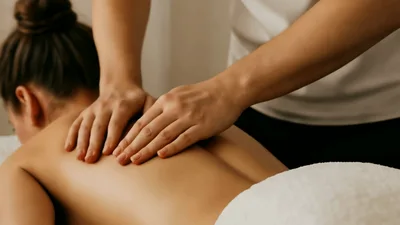 Professional Massage Therapist Performing Back Massage On Client