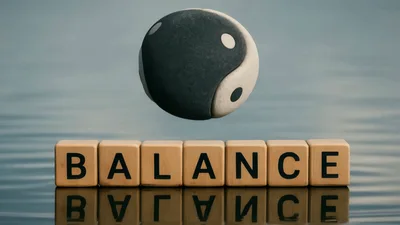 Yin Yang Symbol Rotating Above Balance Letter Blocks