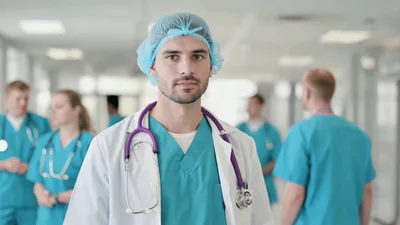 Male Doctor Standing In Hospital Corridor