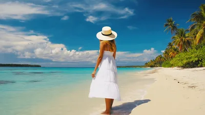 Woman In White Dress Walking On Tropical Beach