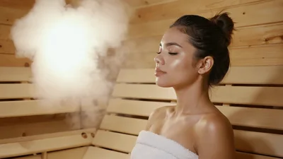 Young Woman Relaxing In A Wooden Sauna With Steam
