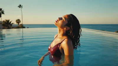 Woman Relaxing In Infinity Pool At Sunset