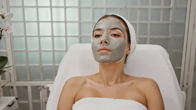 Woman Relaxing With Clay Face Mask In Spa