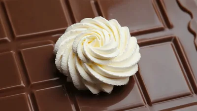 Whipped Cream Swirl Resting On A Chocolate Bar