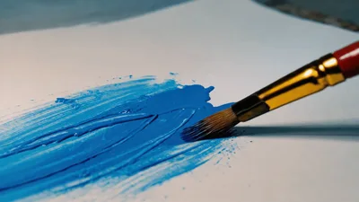 Artist Painting Blue Acrylic Strokes On White Paper