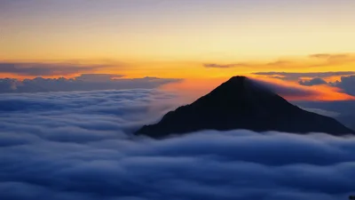 Volcano Peak Rising Above A Sea Of Clouds At Sunset