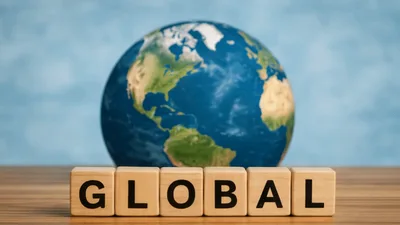 Wooden Blocks Spelling Global In Front Of Rotating Globe