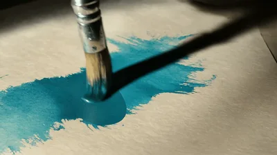 Artist Painting With Blue Watercolor On Paper