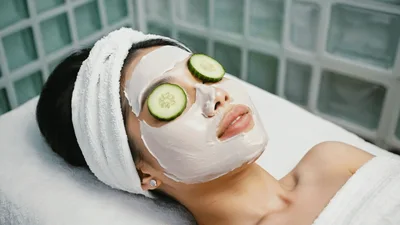 Woman Relaxing With Cucumber Slices On Eyes At Spa